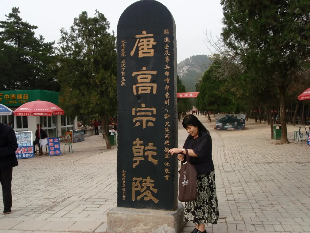In this picture we can see the black color stone pillar with some Chinese language written on it....