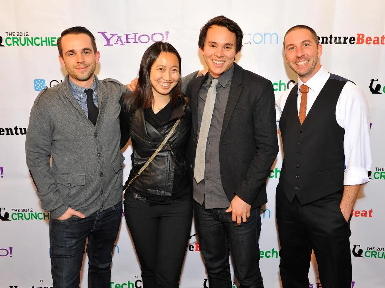 In this image there are a few people standing with a smile on their face are posing for the camera,...