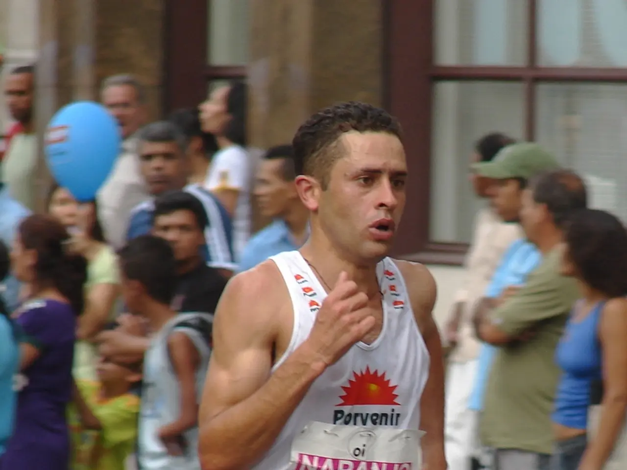 The man in front of the picture wearing white T-shirt is running on the road. Behind him, we see...