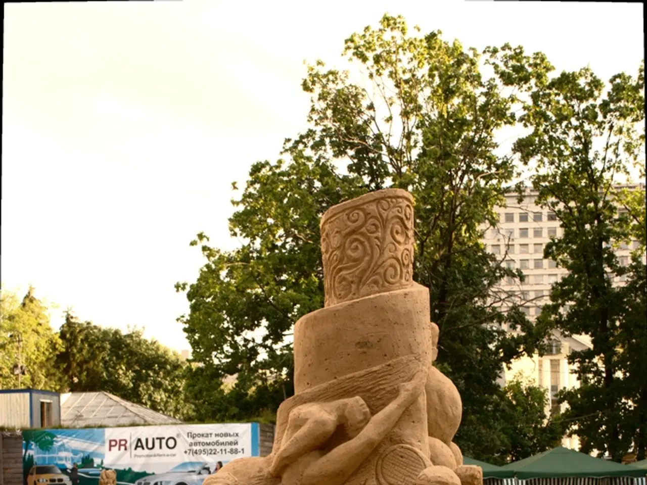 In this image in the middle we can see sand art and around it there is a fence. In the background...