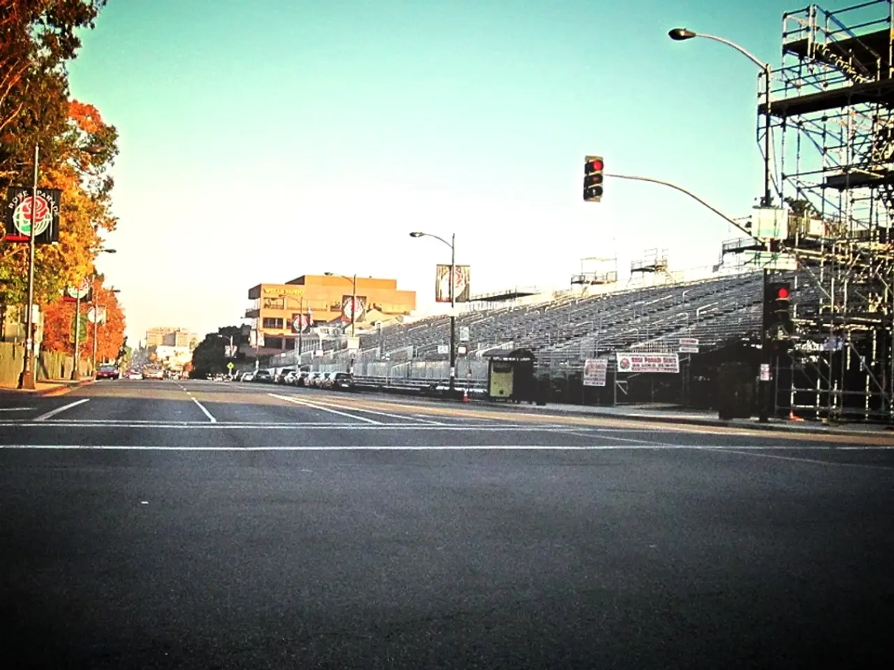 In the image there is a road and on the right side there is a traffic signal pole, beside that pole...