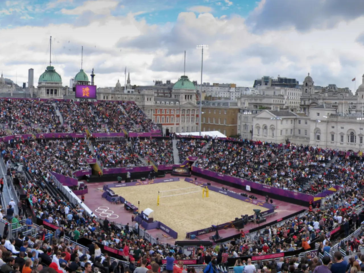 In this picture I can see a playground in the middle, a lot of people are there around this ground,...