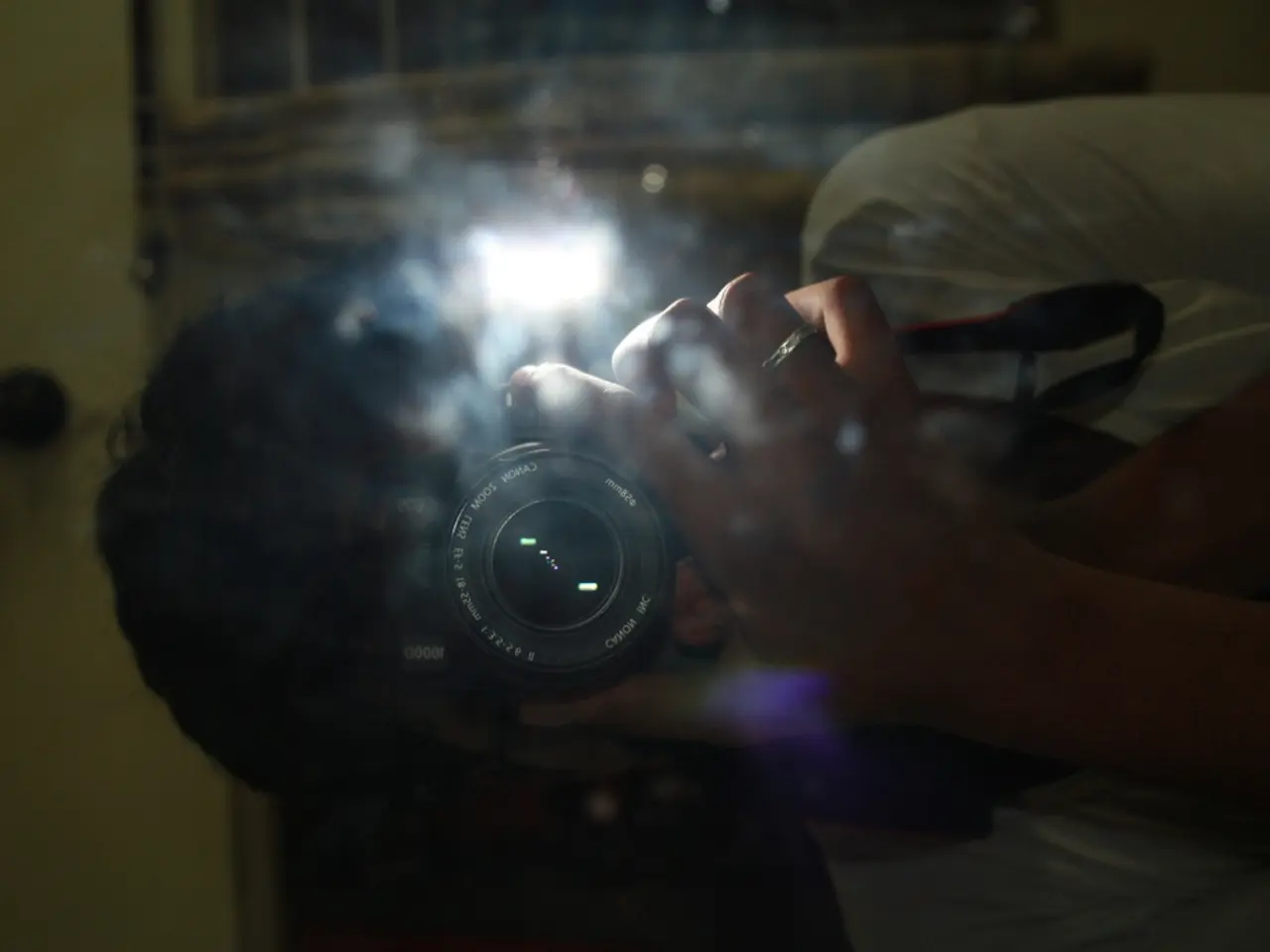 In this picture, we see the man in the white T-shirt is standing. He is holding the camera in his...