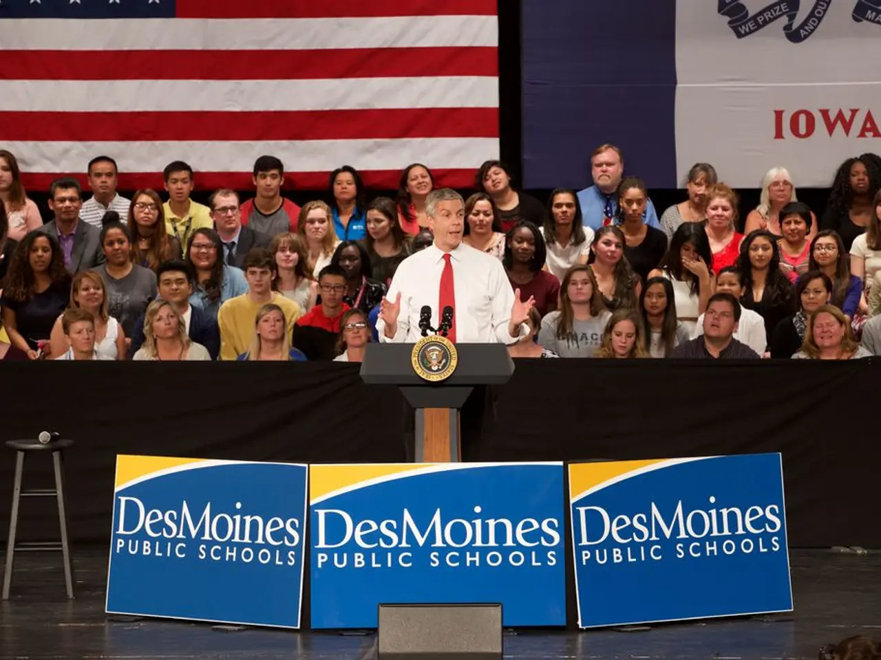 In this image I see a man who is wearing white shirt and a red tie and I see that he is standing in...