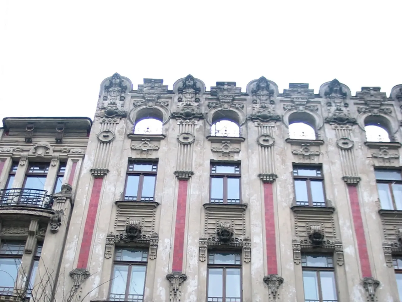 In this image on the bottom left hand corner there is a pole light and there is a big building.