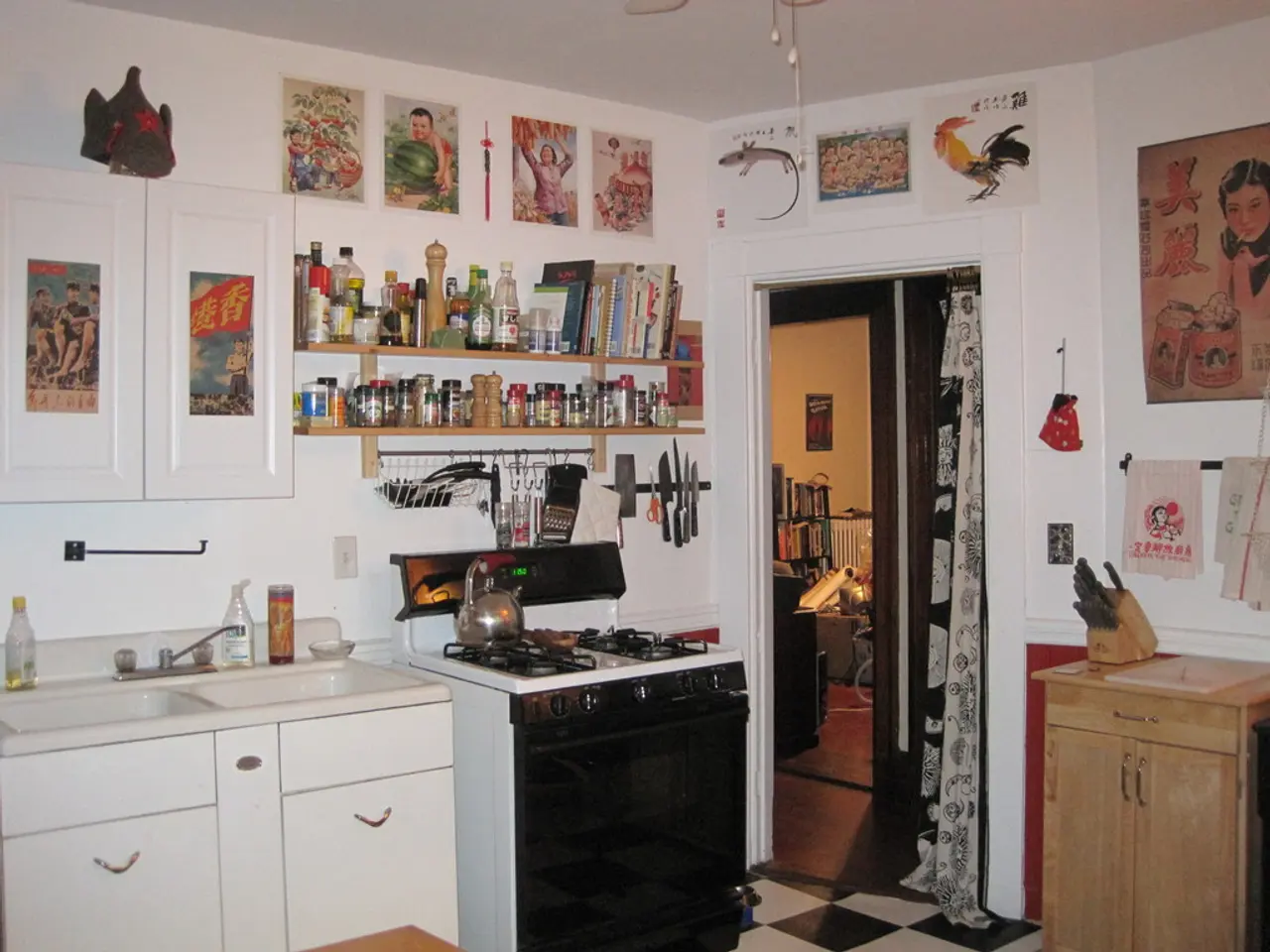In this image there is a gas stove, sink and a table, in the background there is a wall to that...