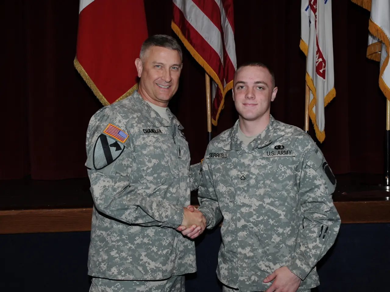 In the middle of this image, there are two persons in uniforms, smiling, shaking hands and...