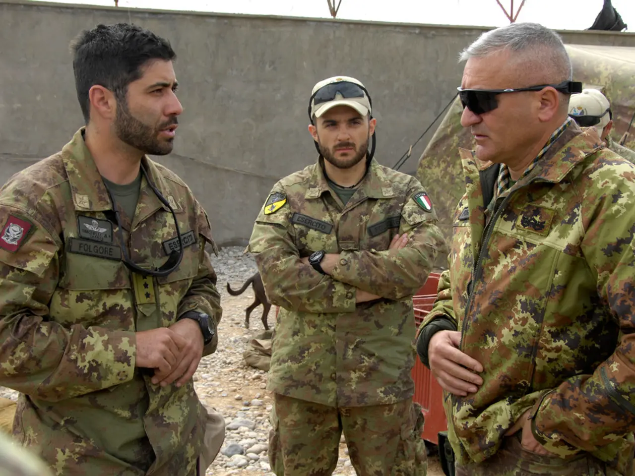 In this picture, we see five men in the uniform are standing. The man on the left side is talking...