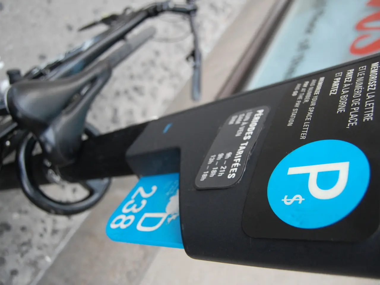 This image consists of a cycle kept on the ground. On the right, we can see a parking meter. At the...