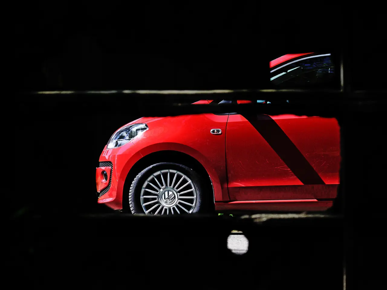 There is a red color car and the background of the car is dark.