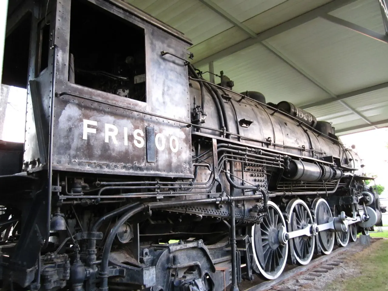 In this image in the center there is a train, and at the bottom there is grass and railway track....