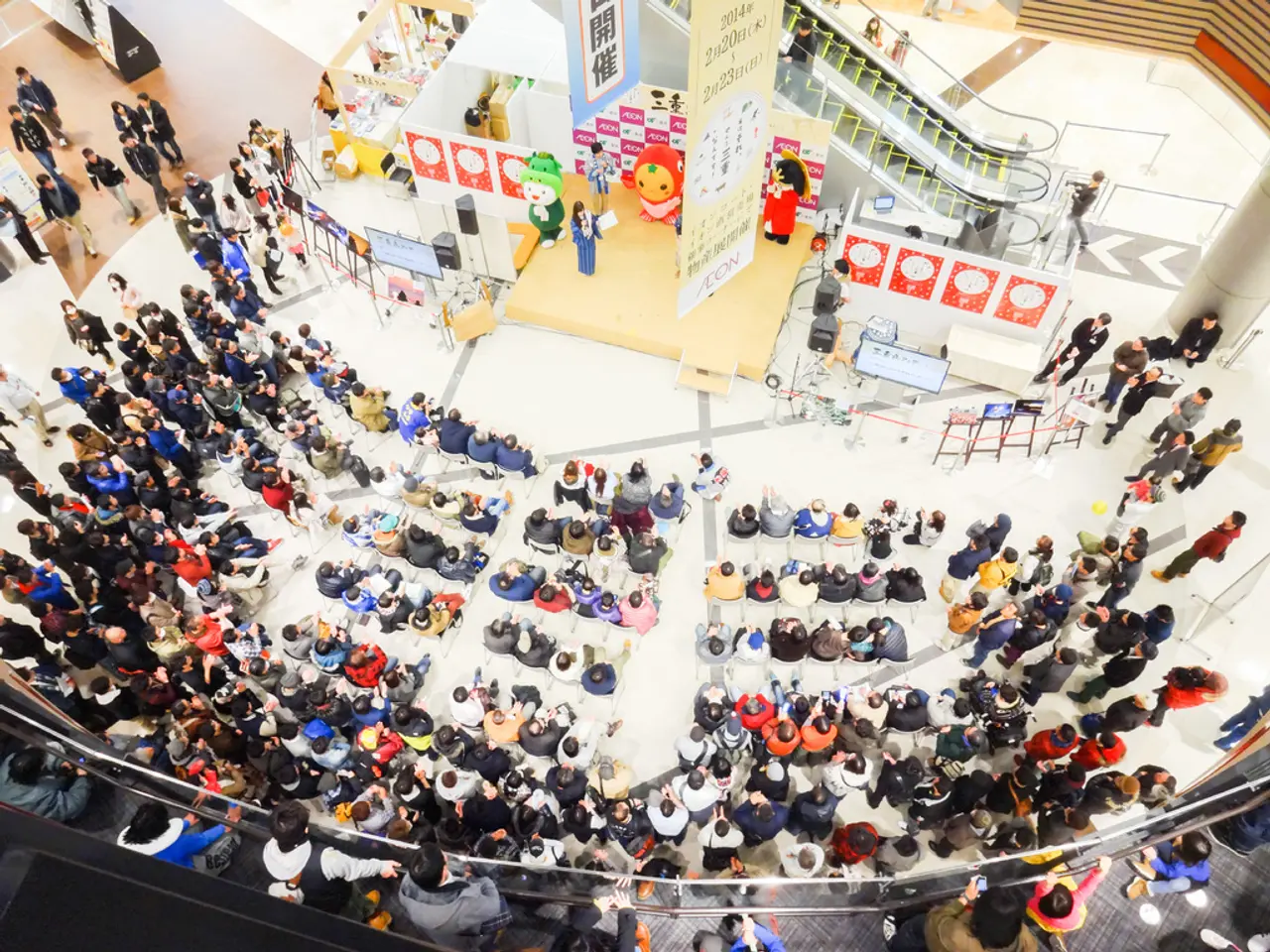 This image is clicked from a top view. There are many people sitting on the chairs. Beside them...
