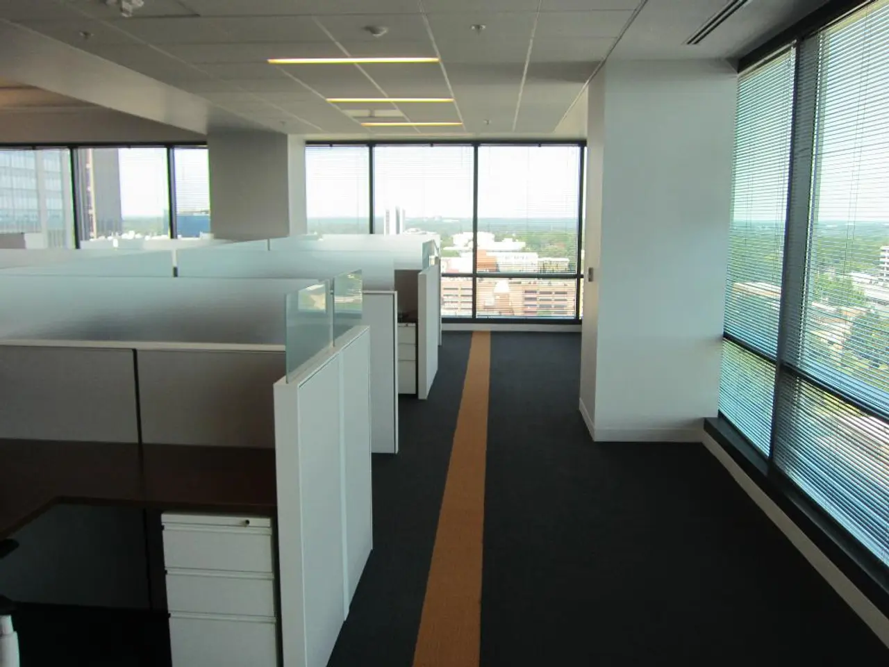 It is an interior part of an office room, in the left side there are work desks which are in white...