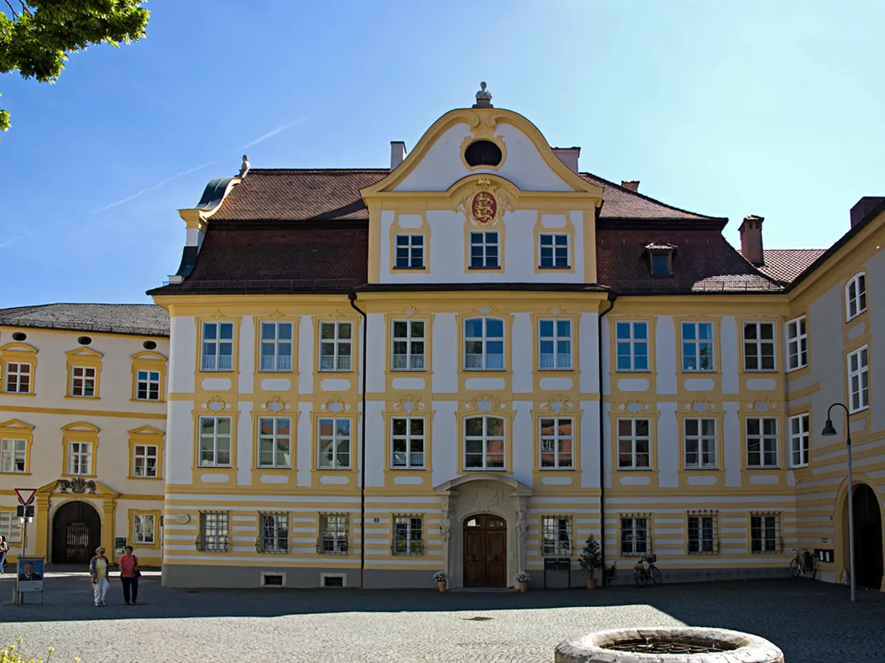 In this picture there is a beautiful white and yellow house with many glass windows. In the front...