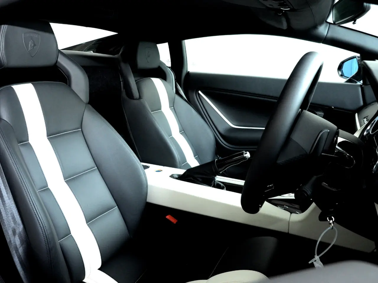 This picture is clicked inside the car. To the left there are car seats. In the between the car...