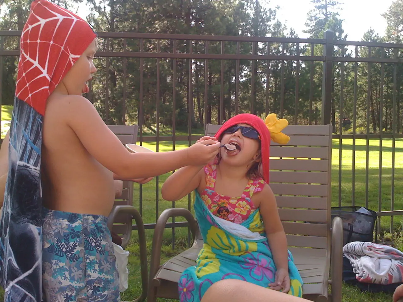 To the left side of the image there is a boy with short and a cloth on his head. He is holding the...