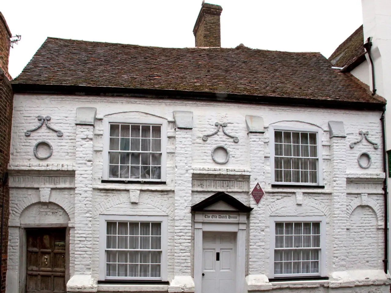 In this picture we can see white color house. On the top there is a brown color roofing tile and a...