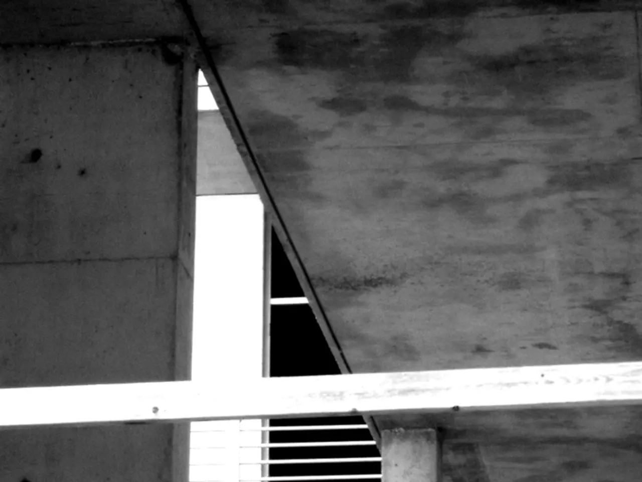 In this picture I can see there is a building and there is a railing. This is a black and white...