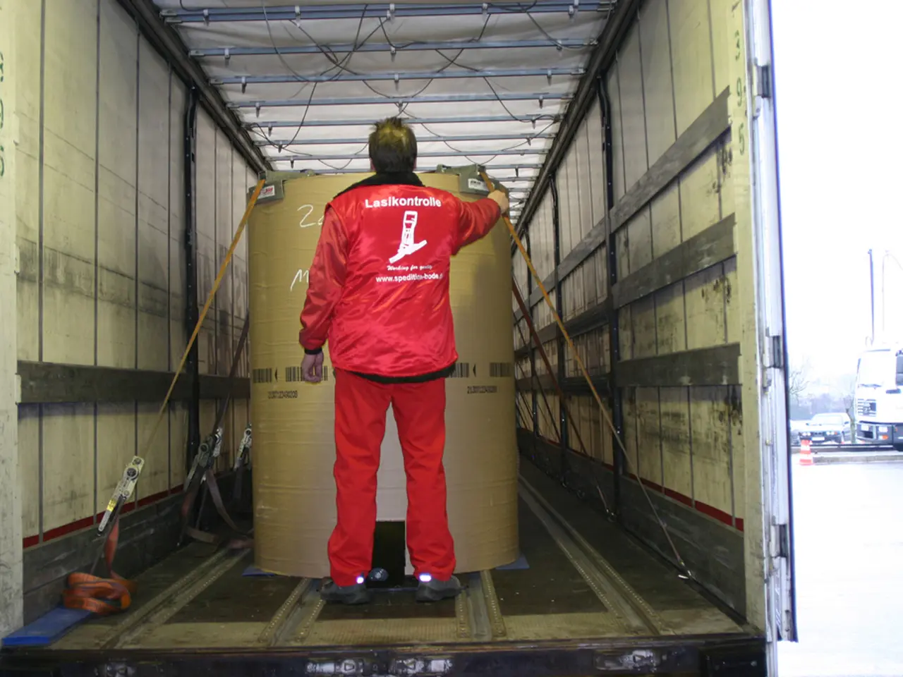 In this picture we can see a person holding a drum inside the truck, side we can see few vehicles...