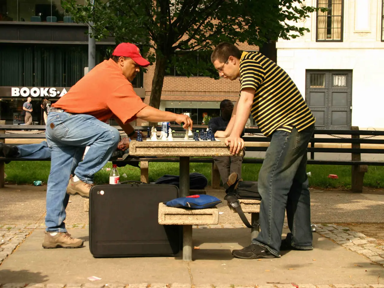 This picture is clicked outside in the city. There is a table and benches in the image. On the...