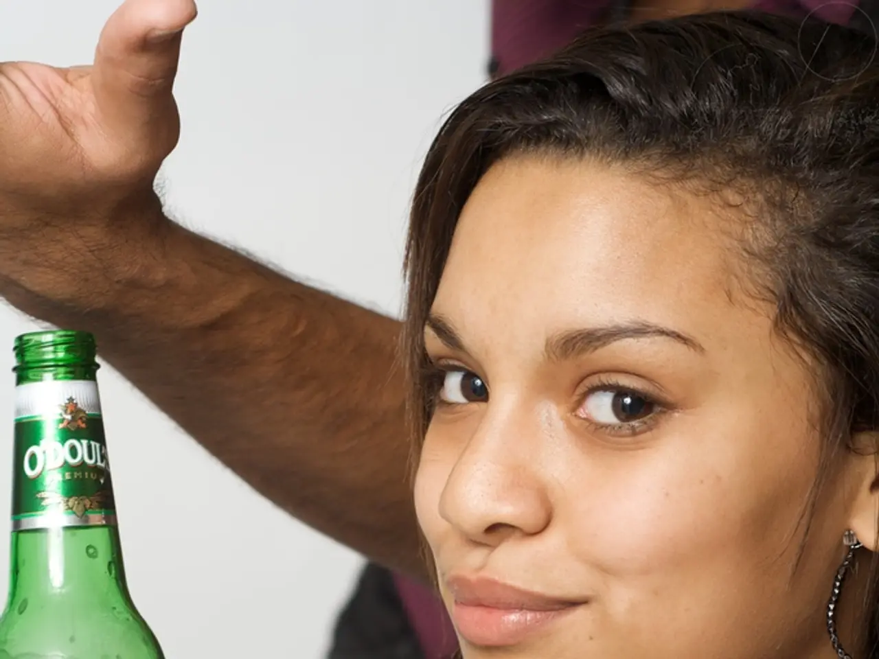 In this image there is a lady person wearing blue color dress holding a bottle.