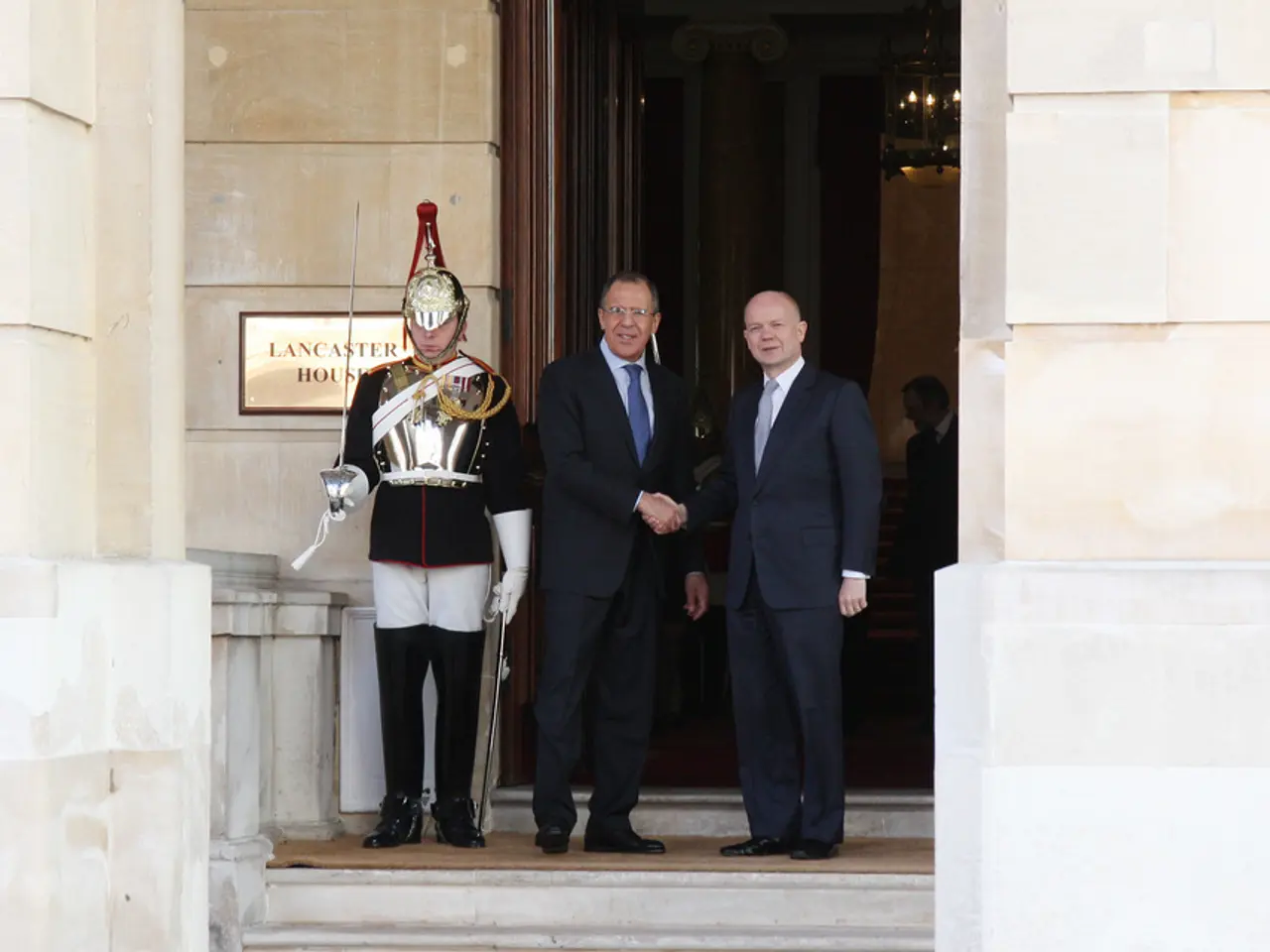 In this image we can see three men are standing on the stairs. One man is wearing army uniform and...