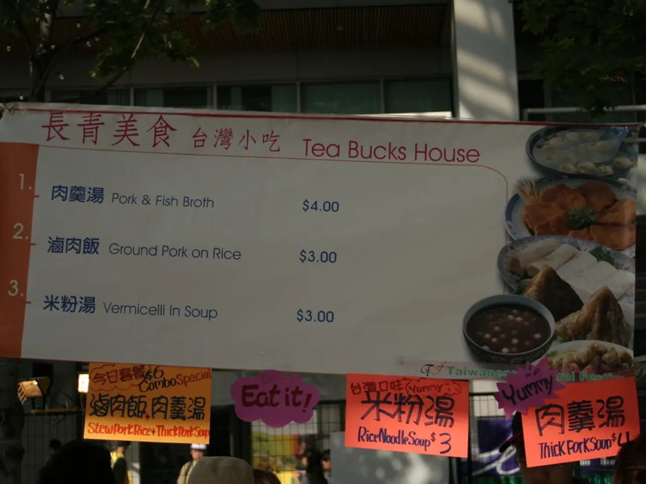 In the background we can see the buildings, windows and trees. In this picture we can see a banner...