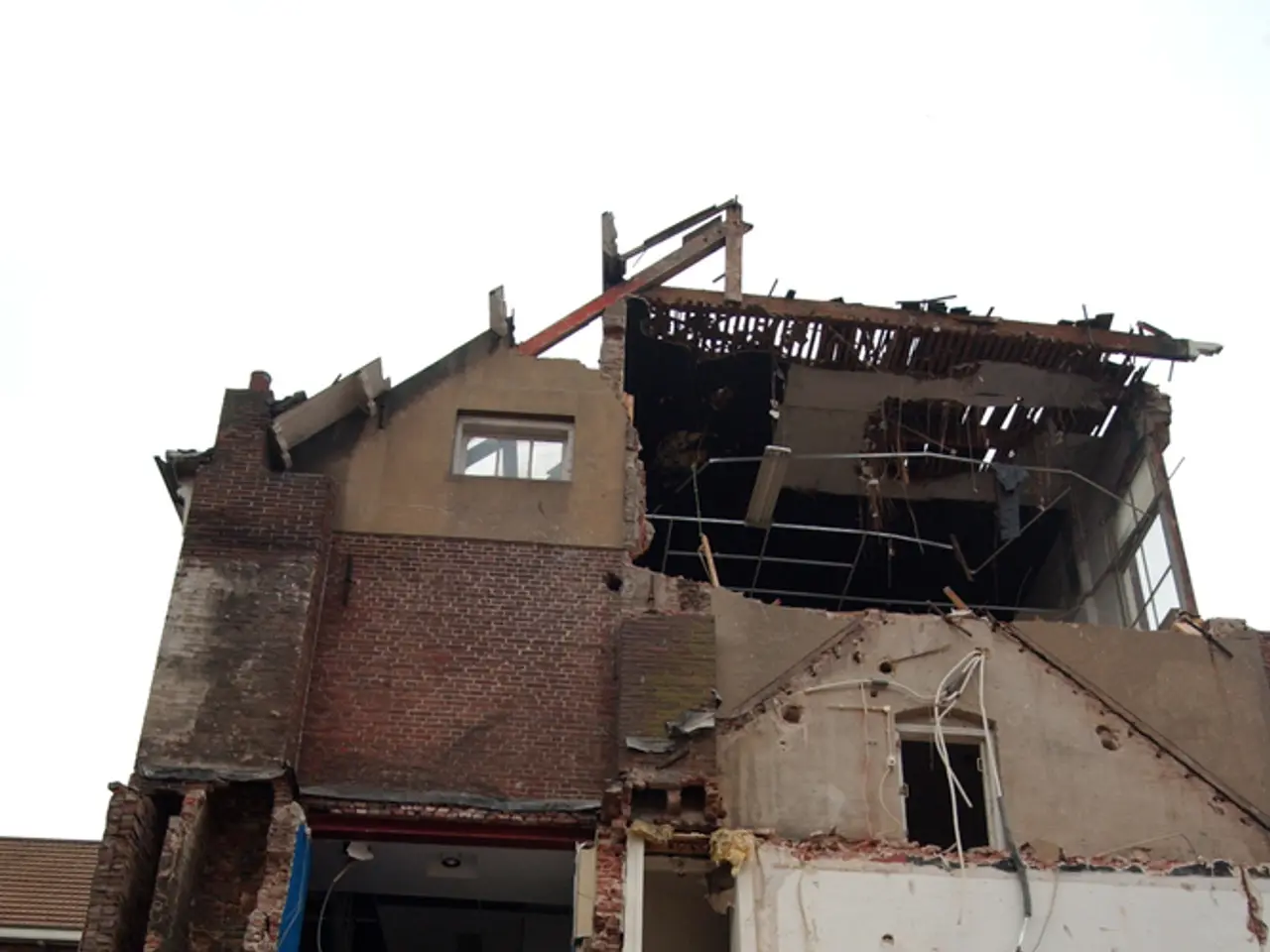 In the picture we can see a building which is collapsed and top of the picture there is clear sky.