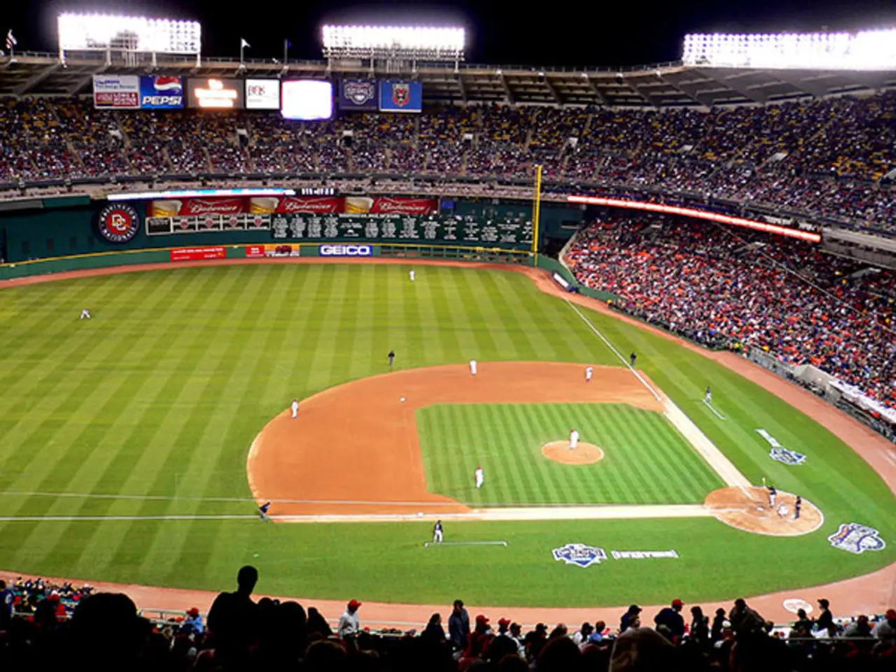 This is a baseball game stadium. In this image we can see few persons are playing base ball game on...