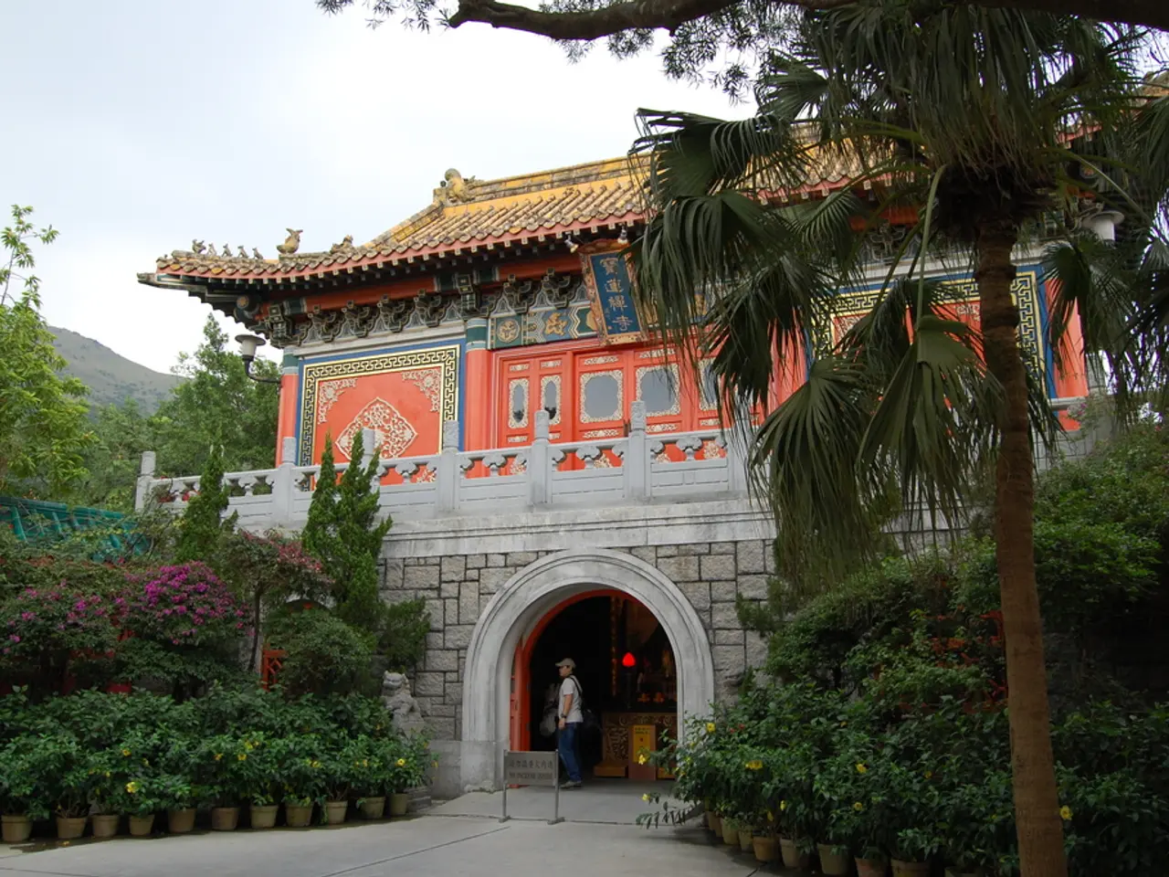 In this picture there is a Po Lin monastery in the center of the image and there are trees on the...