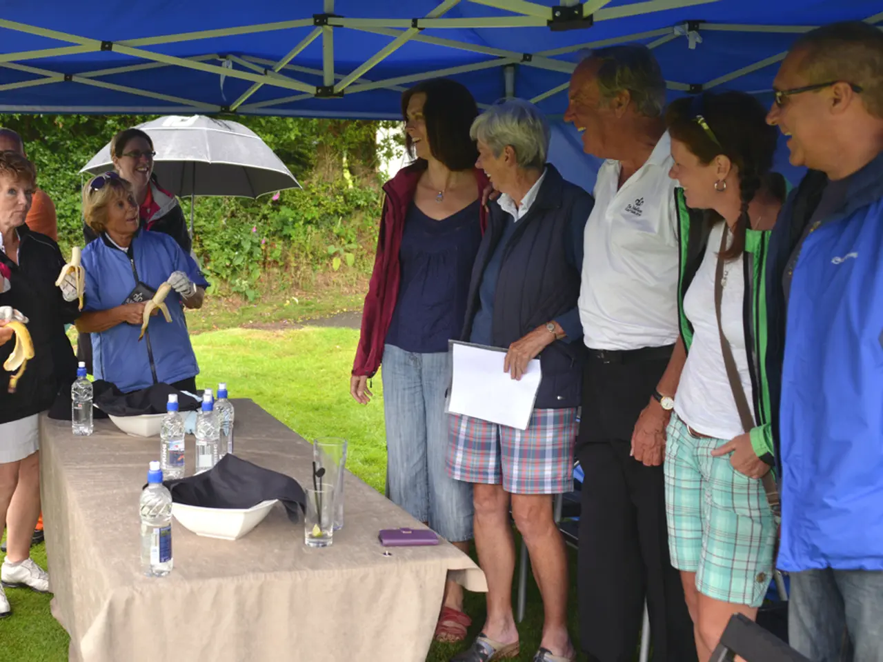 This image is taken in outdoors. In the right side of the image five people are standing, three men...