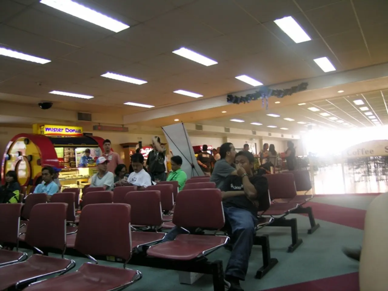 This is an inside view. Here I can see few people are sitting on the chairs facing towards the left...