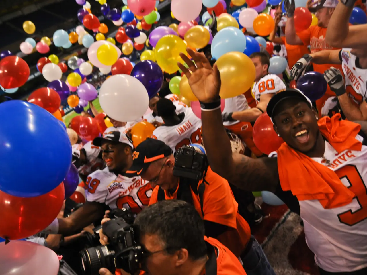 In this picture I can see there are few persons standing and they are wearing white and orange...