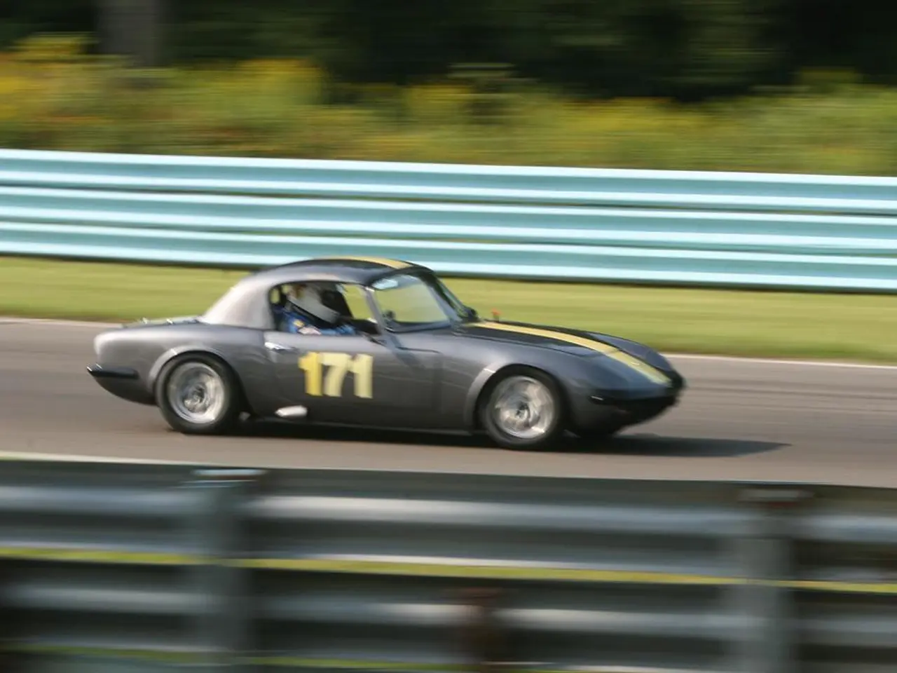 In this image on a road a car is moving inside it a person is sitting wearing helmet. In the both...
