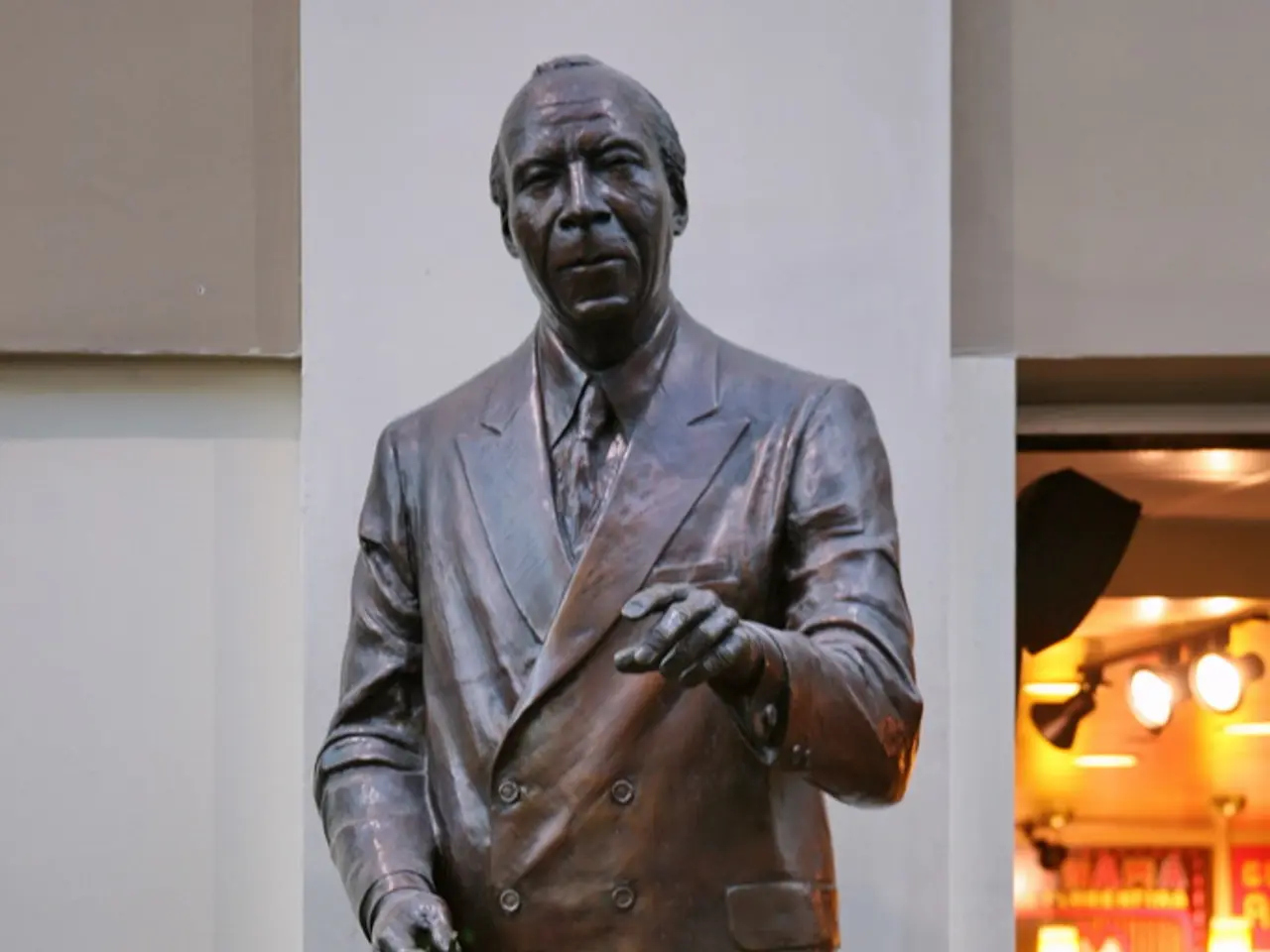 In this image there is a statute, under the statute there is some text, in the background there is...