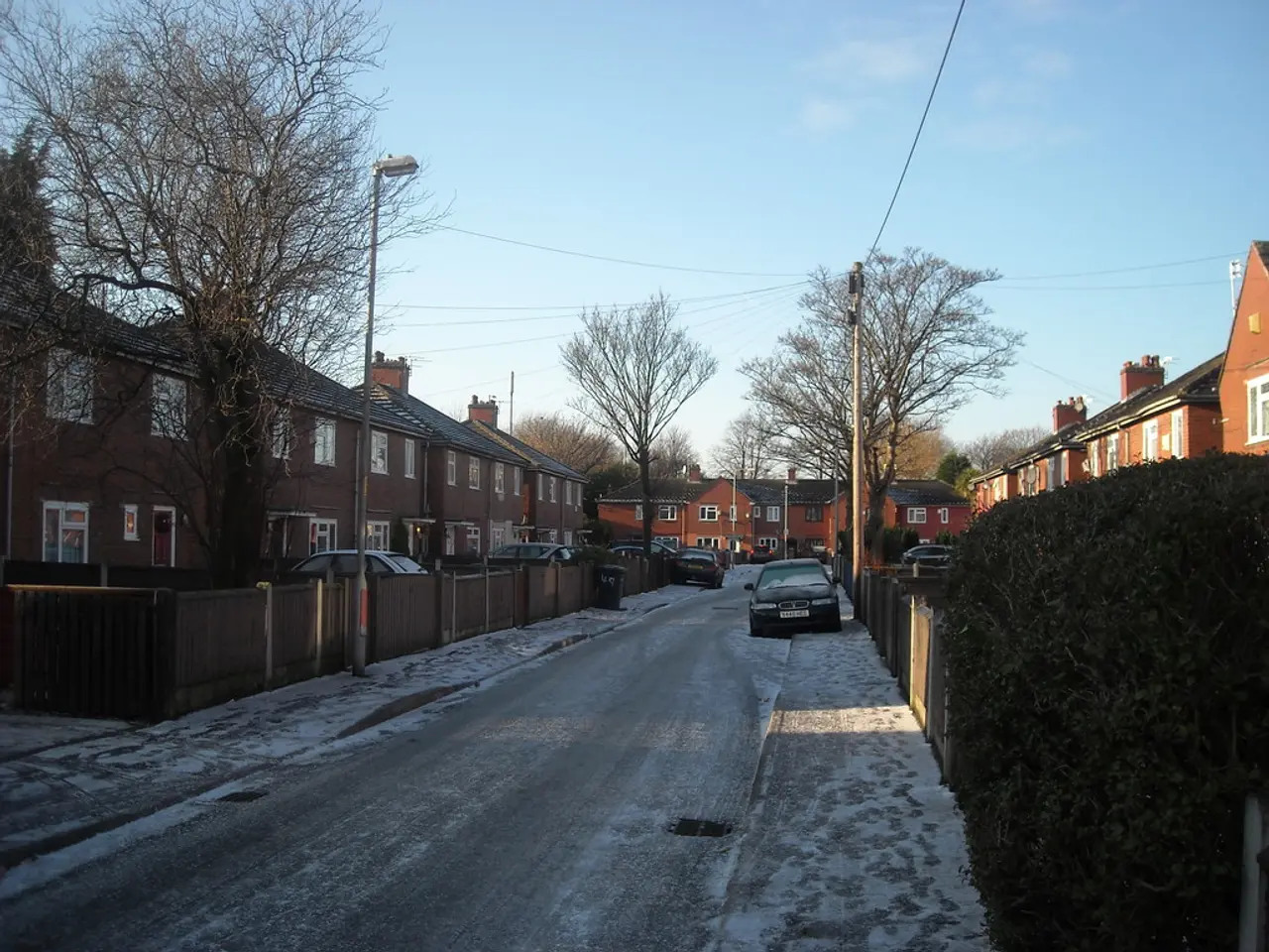 In this image there is road, there are vehicles, there is a dustbin, there is a pole, there is a...