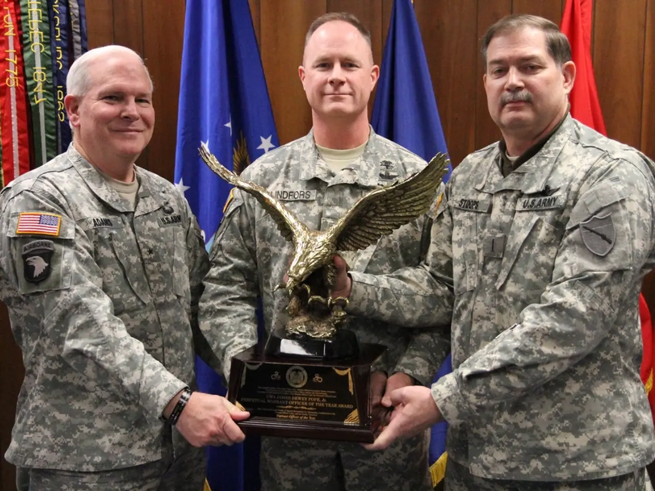 In this image I can see three men are standing in the front and I can see all of them are holding...