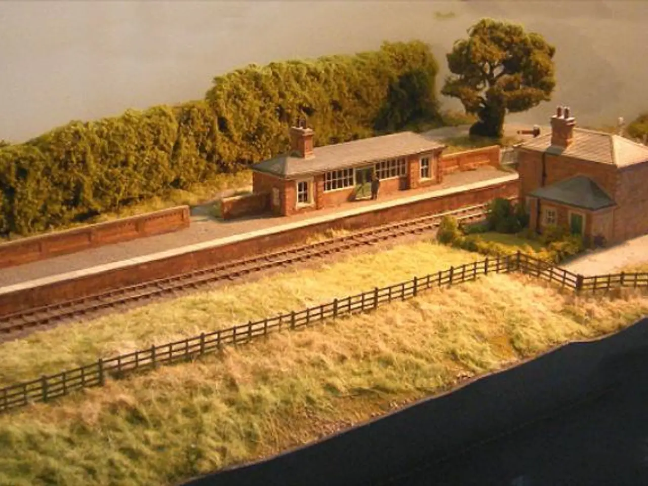 This image is an art. In the middle, there are houses, platform, railway track, trees, fence,...