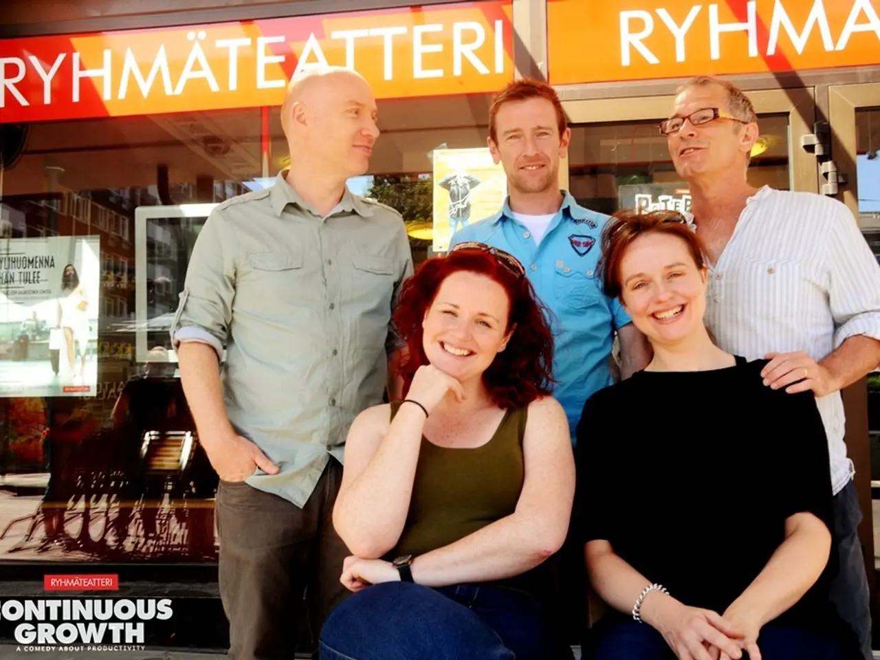 In the picture we can see three men are standing and two women are sitting in front of them and...