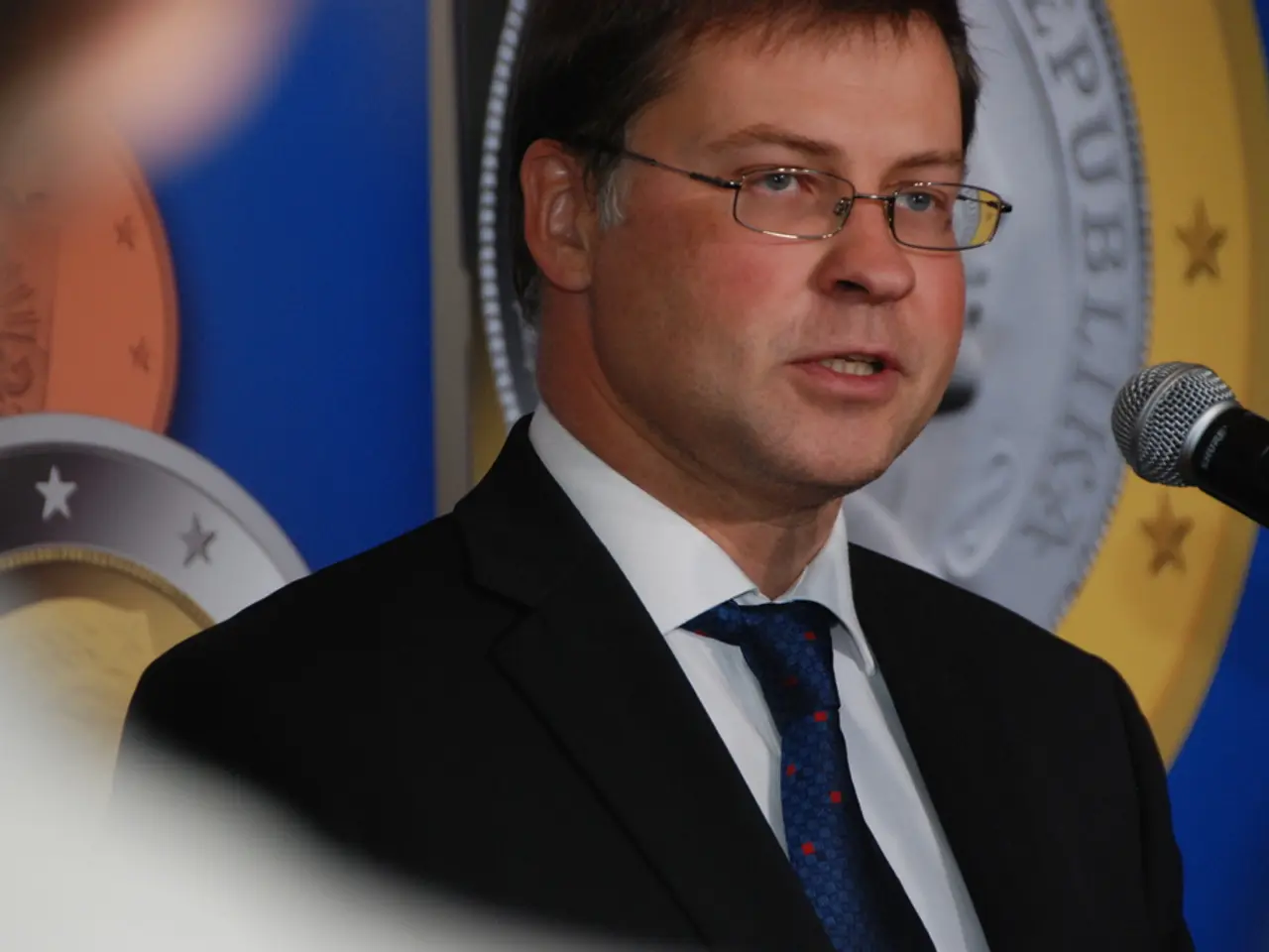 In the image there is a man with black jacket, white shirt and blue tie is talking and in front of...