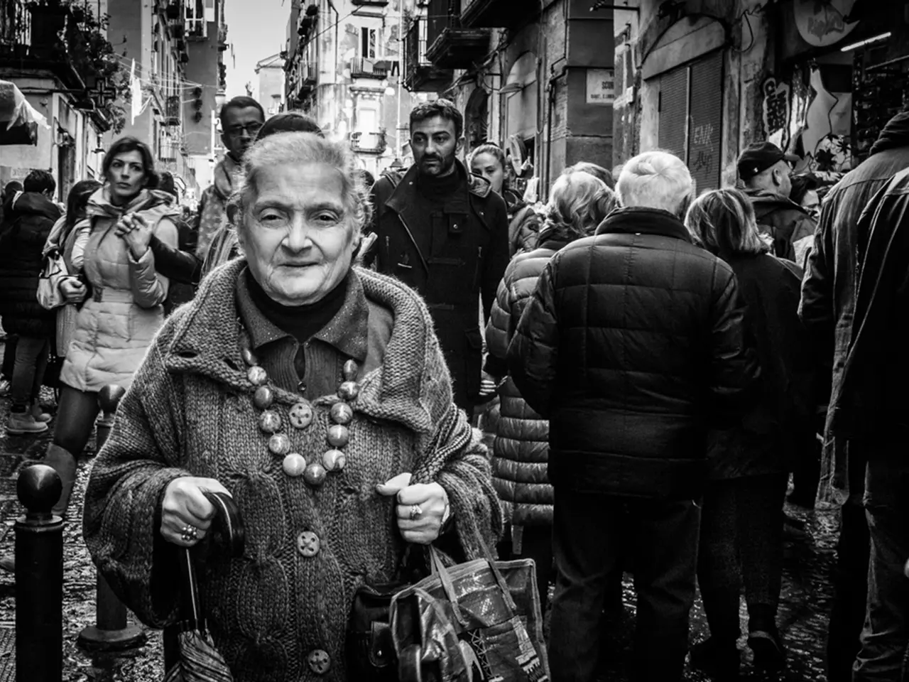 In this image there are group of people, there are buildingś, there is sky, there is a person...