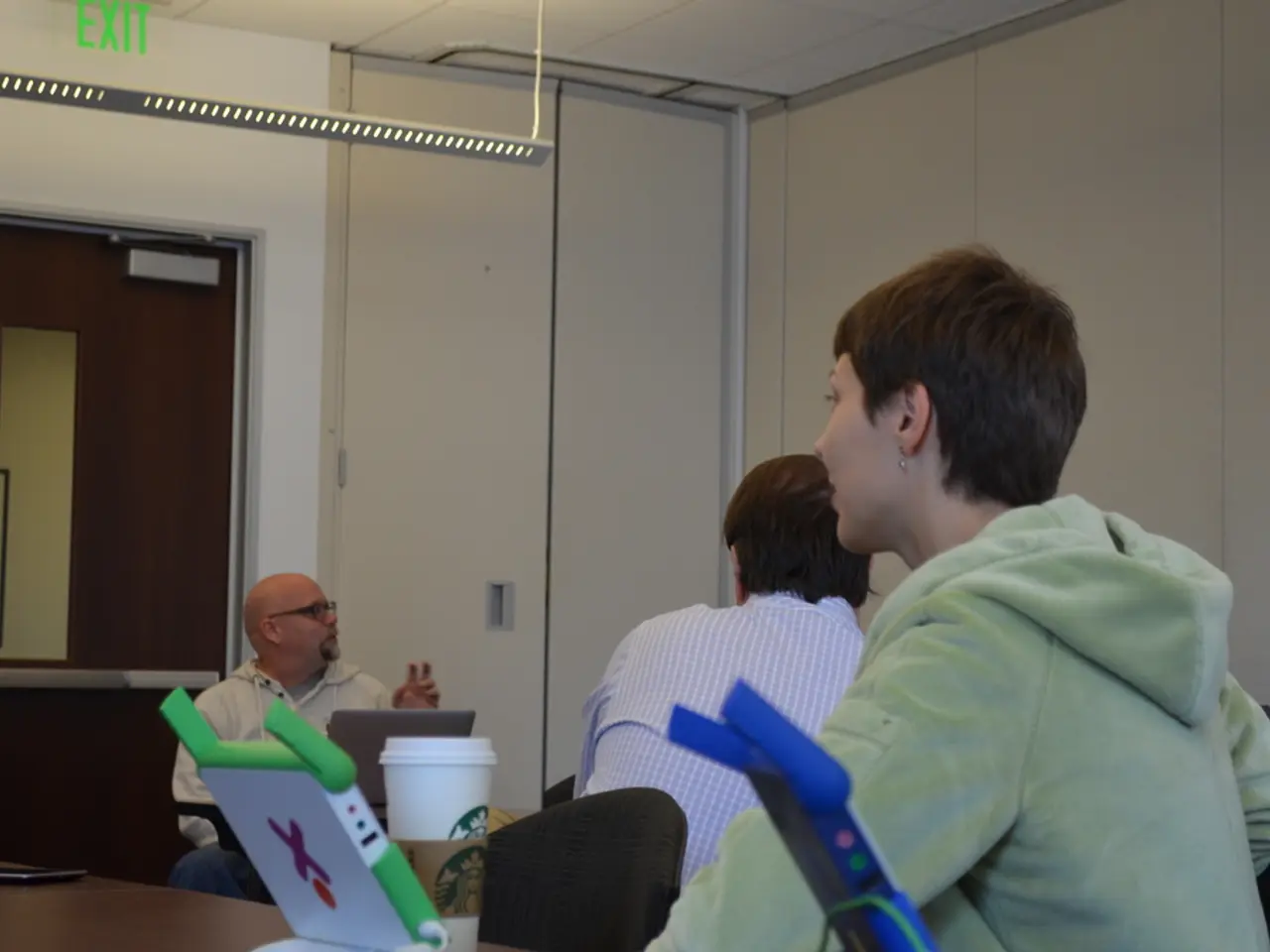 In this image, we can see persons wearing clothes. There is door on the left side of the image....