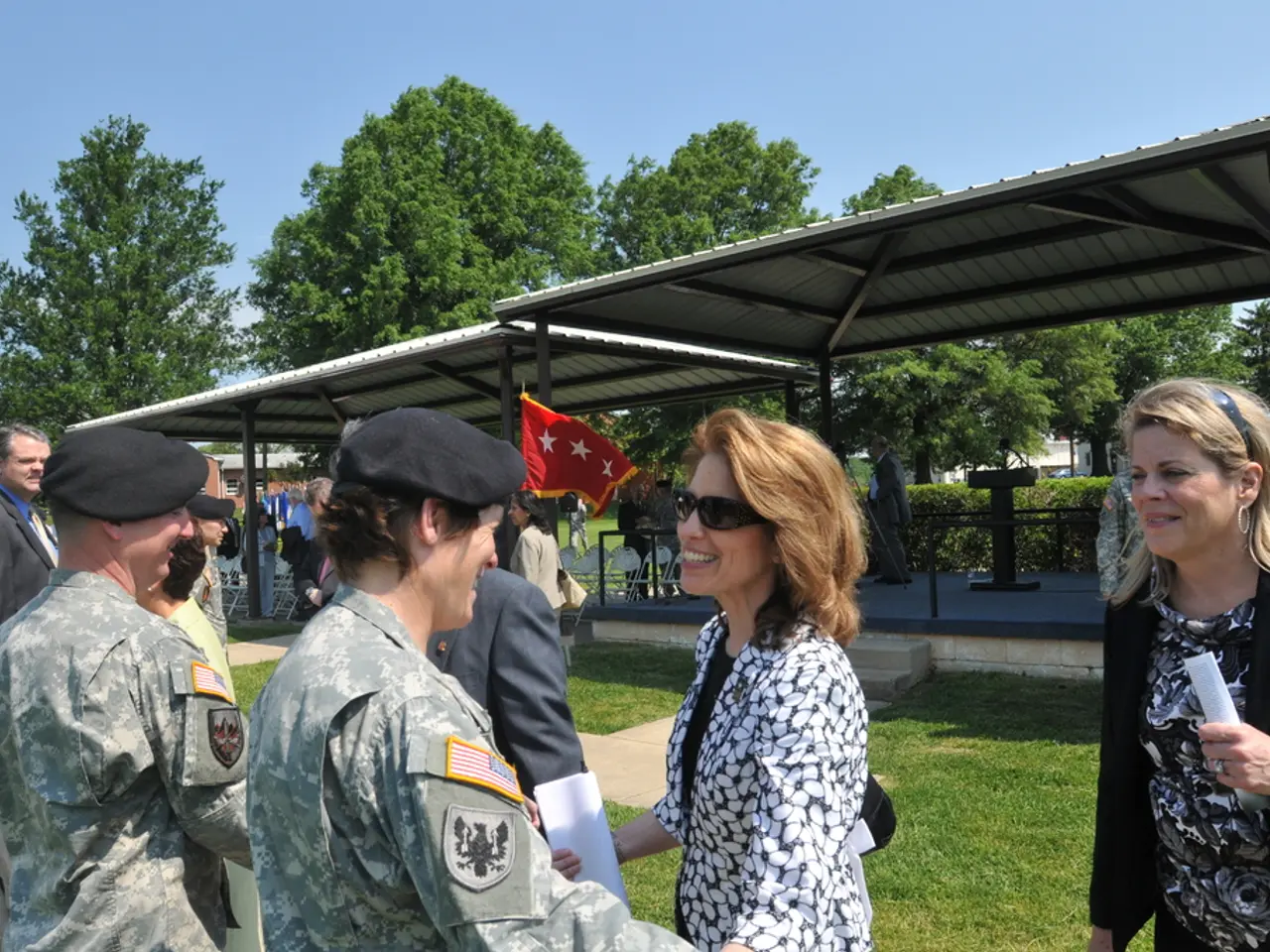 In this picture there are people and soldiers in the center of the image on the grassland and there...