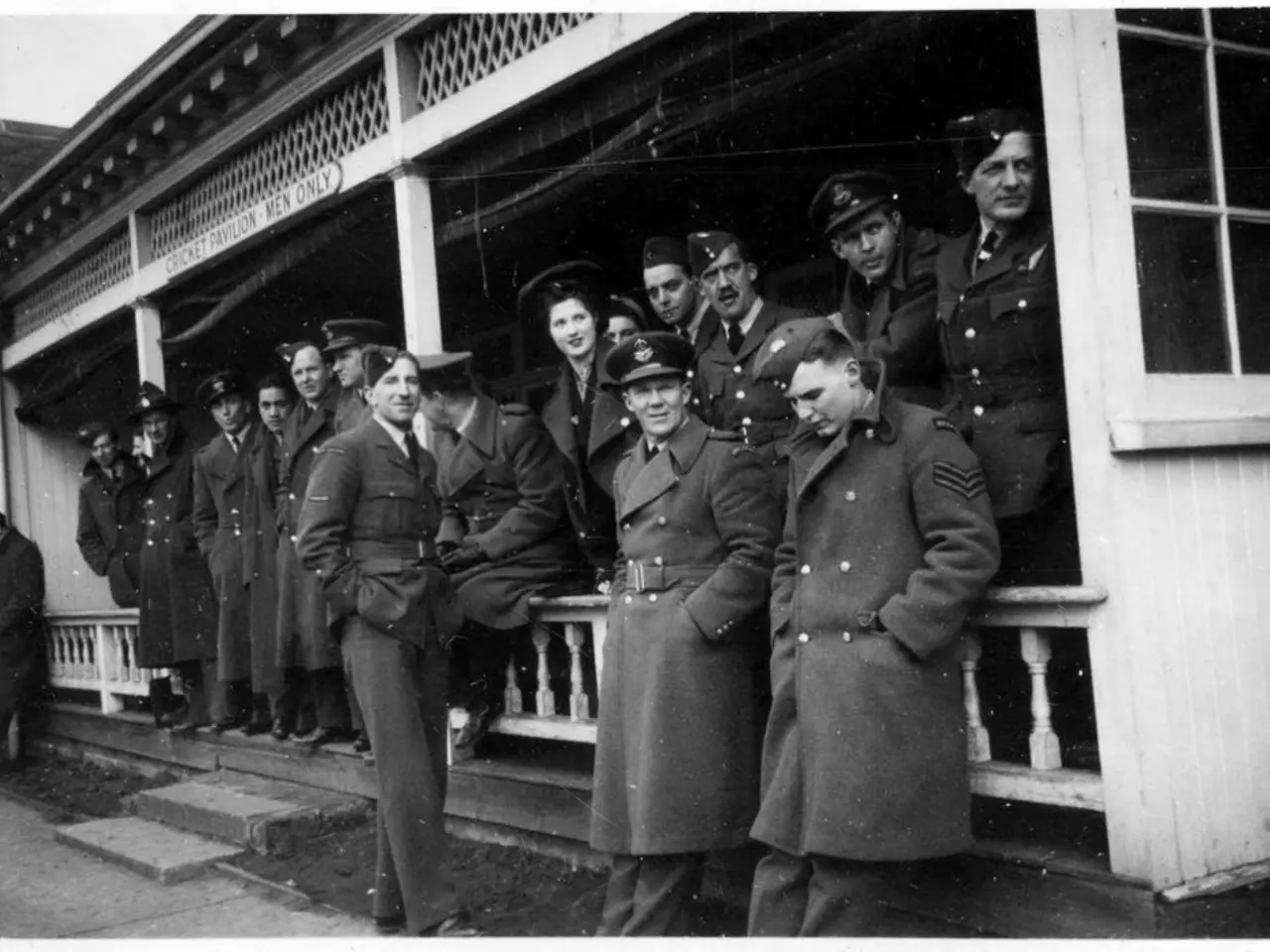 This is a black and white image. In the foreground of the picture there are lot of people standing...