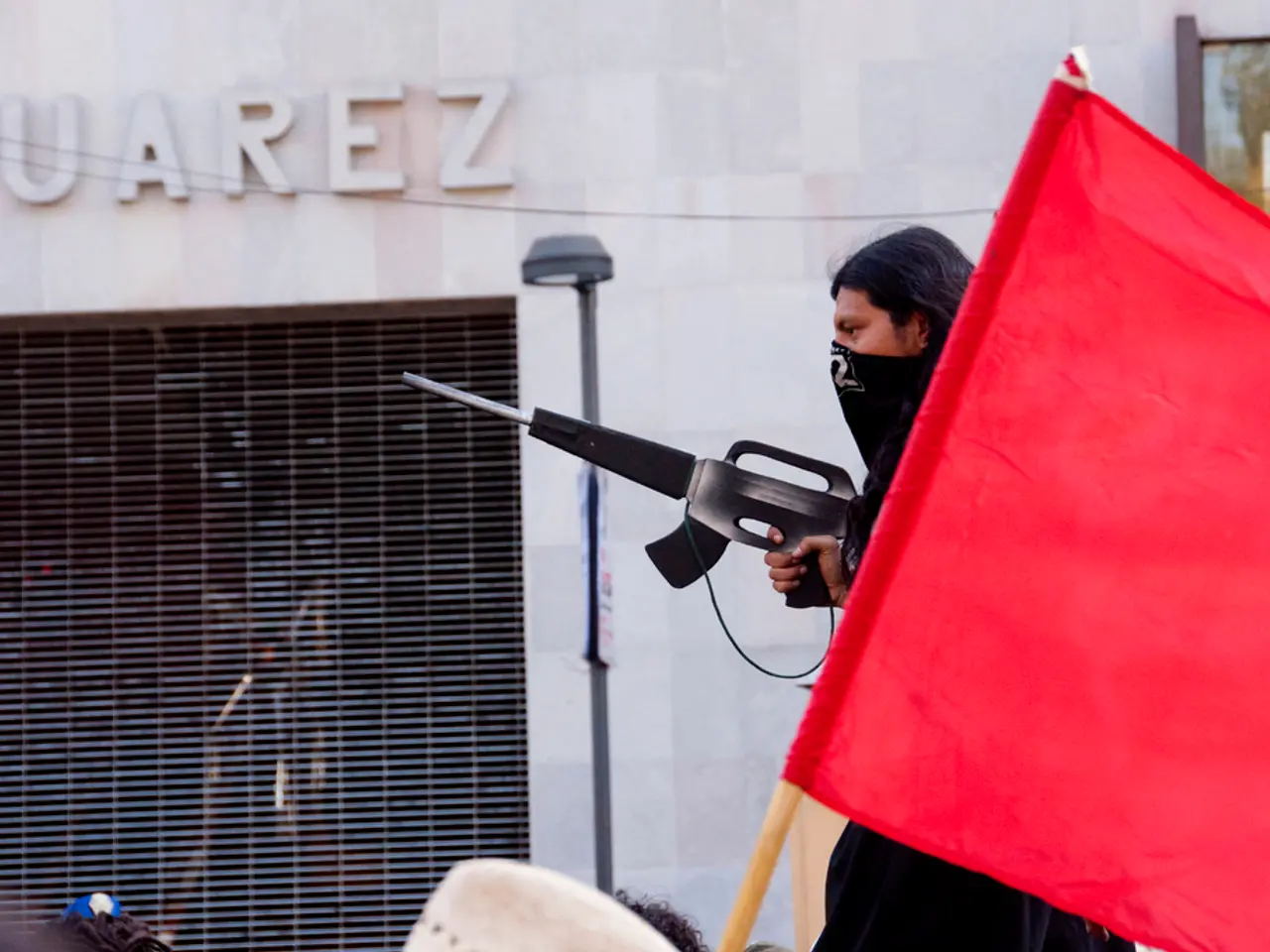 In this picture there is a man who is wearing black dress and holding the gun. On the right I can...