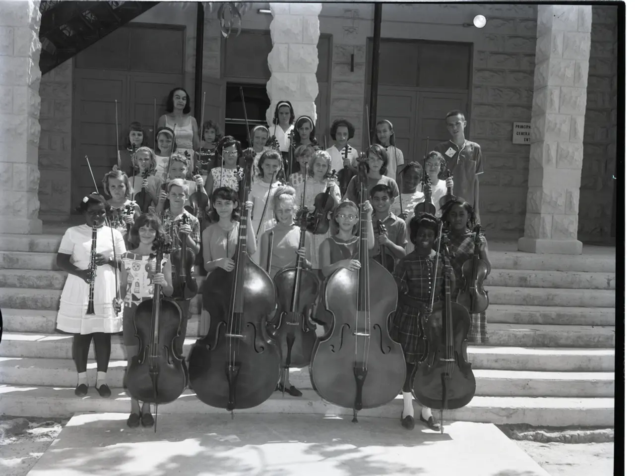 In this black and white picture there are children standing on the steps. They are holding musical...