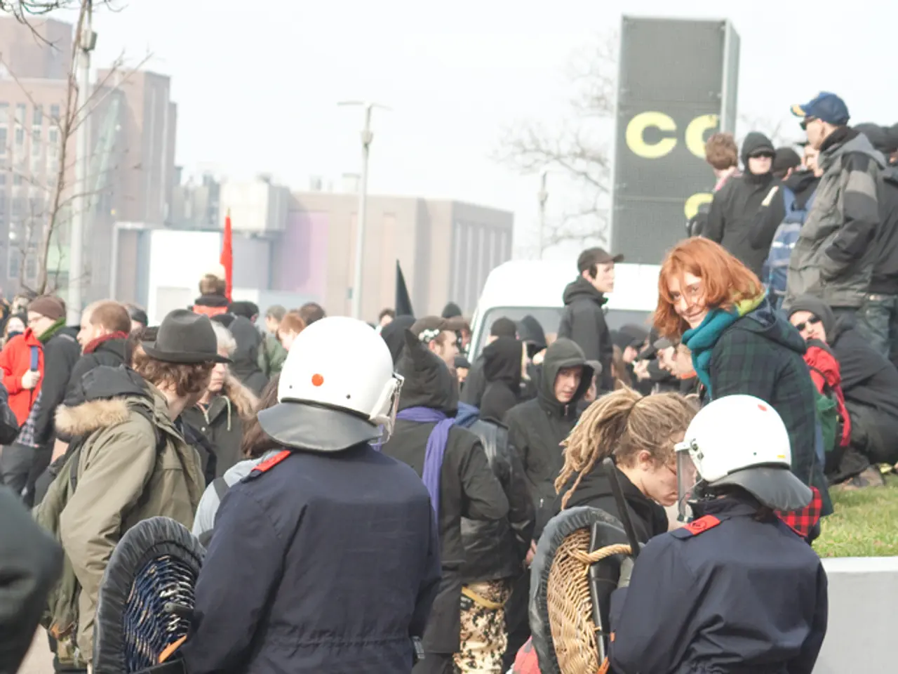 This image consists of many people walking on the road. In the front, the two persons look like...