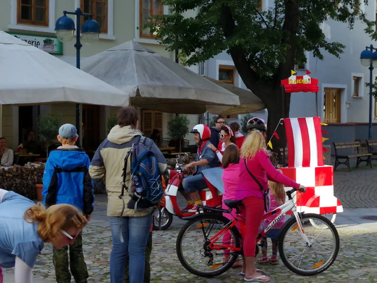 This is an outside view. Here I can see few people are riding their bicycles and few people are...