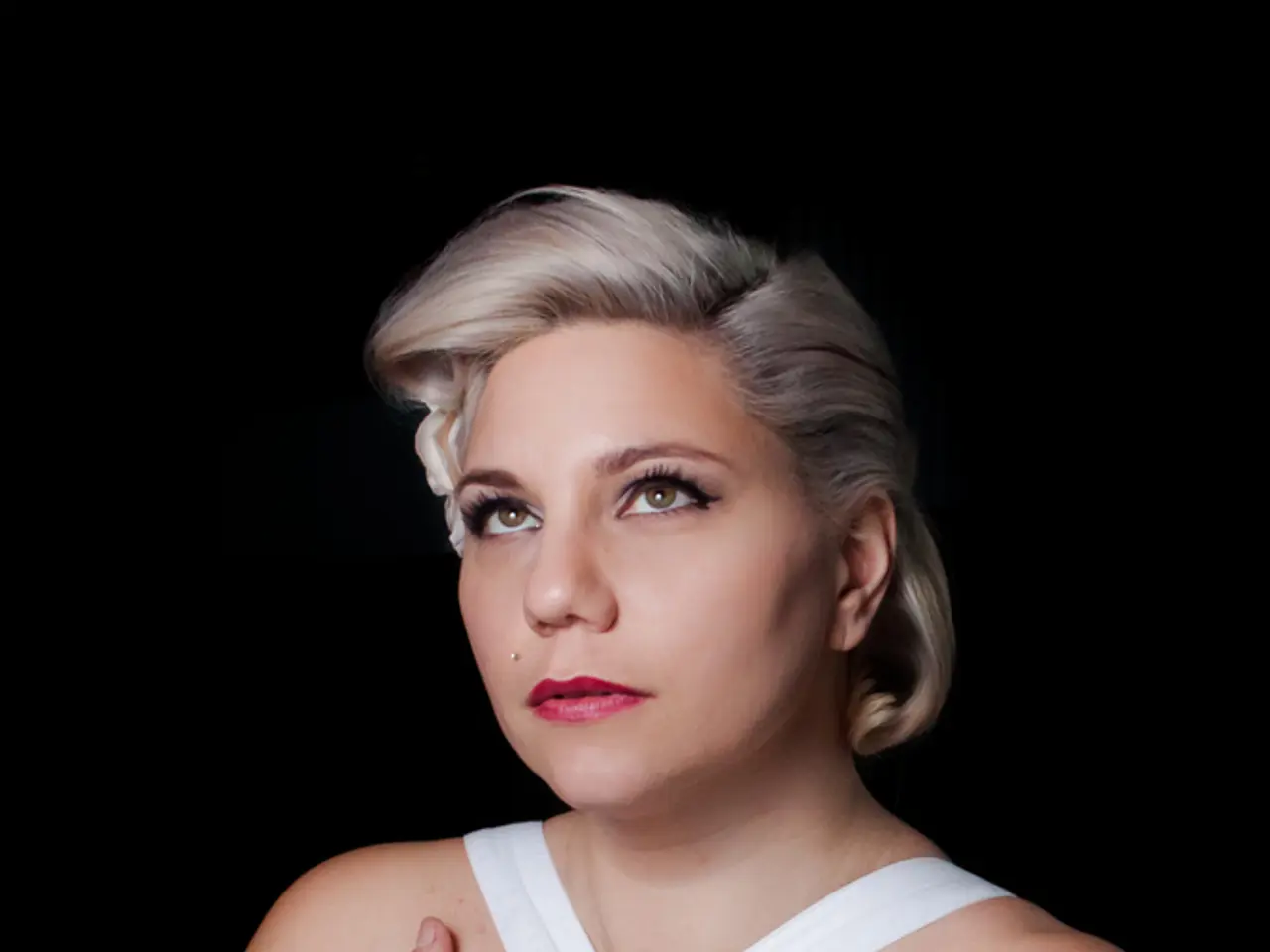 In this picture there is a woman. In the background of the image it is dark.