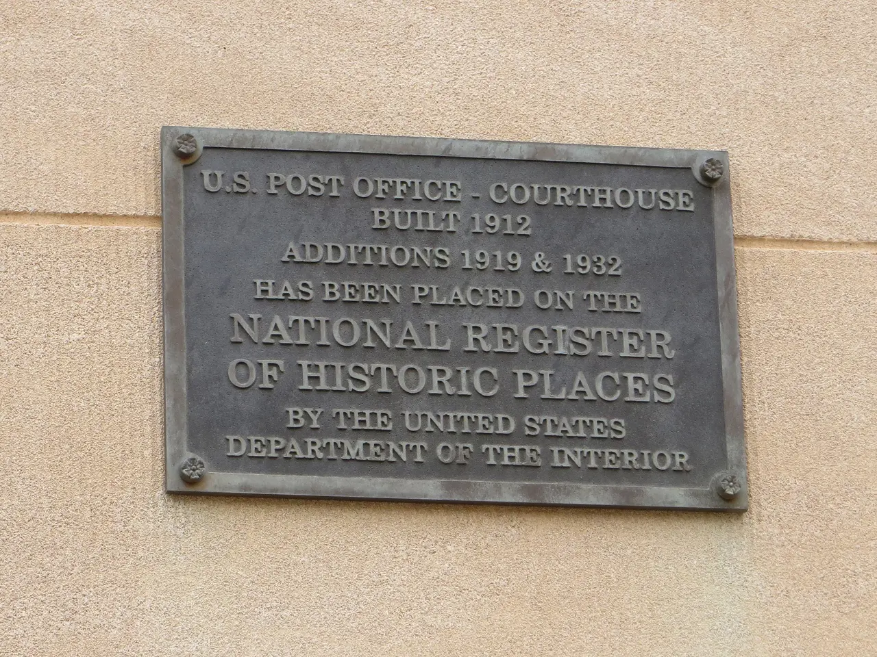 The image shows a plaque on the side of a building that reads "National Register of Historic...